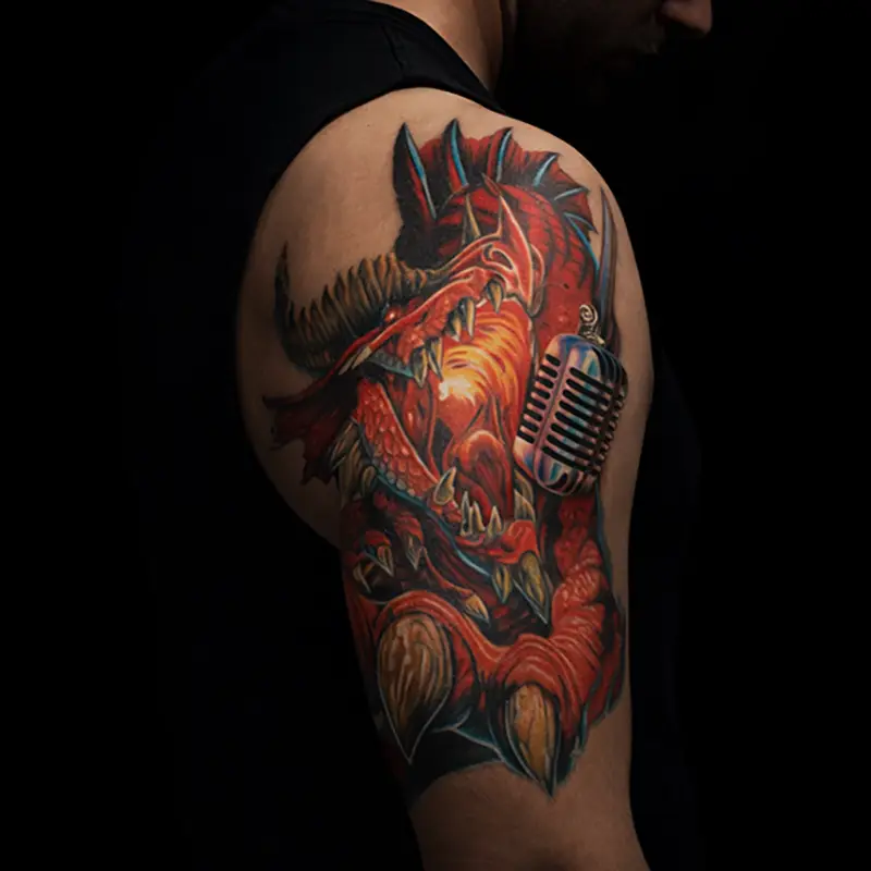 Color dragon shoulder tattoo wrapped around vintage microphone.