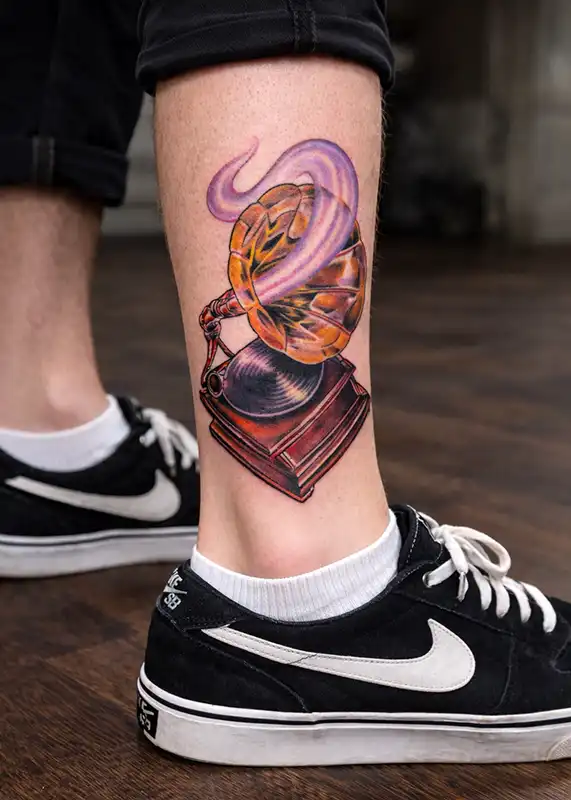 Color illustrative tattoo of a vintage gramophone record player with smoke.